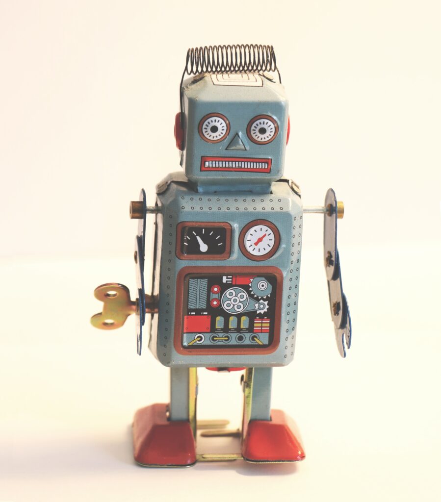 Vintage toy robot with spring hair, red eyes, dials, and meters on a light background.