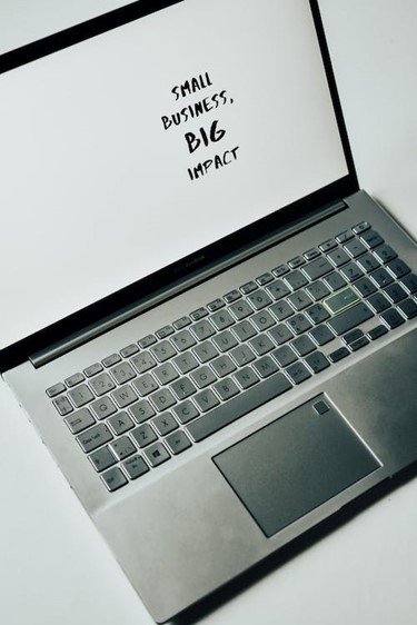 A laptop with the text "Small Business, Big Impact".